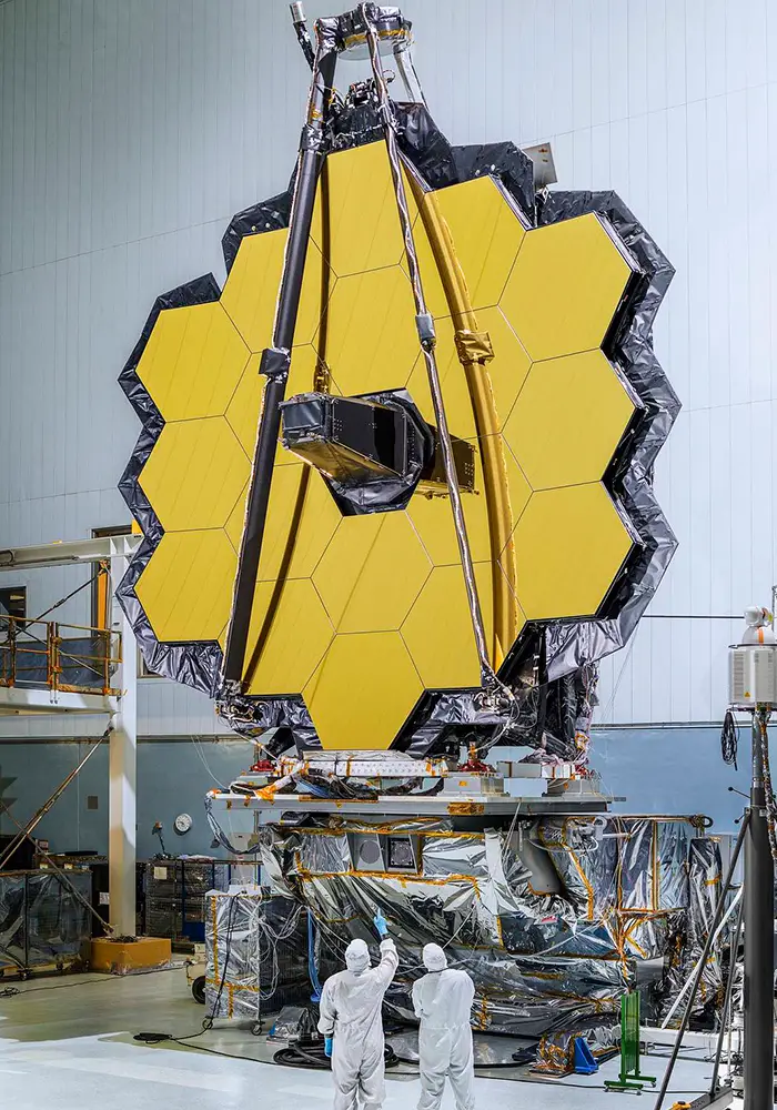 Engineers at Goddard Space Flight Center inspect the 6.5-meter diameter JWST primary mirror after installatin of the 18 hexagonar mirror segments.